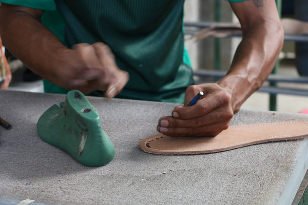 Handcrafted huarache being woven by a skilled artisan using traditional Mexican techniques, showcasing intricate weaving patterns and high-quality leather.